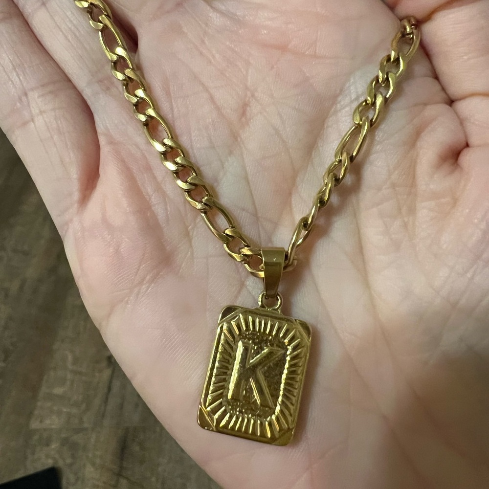 Gold necklace. “K” initial.
